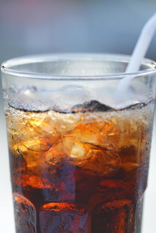 Soft drink in a glass with straws on a table at a restaurant. with blurred background photo