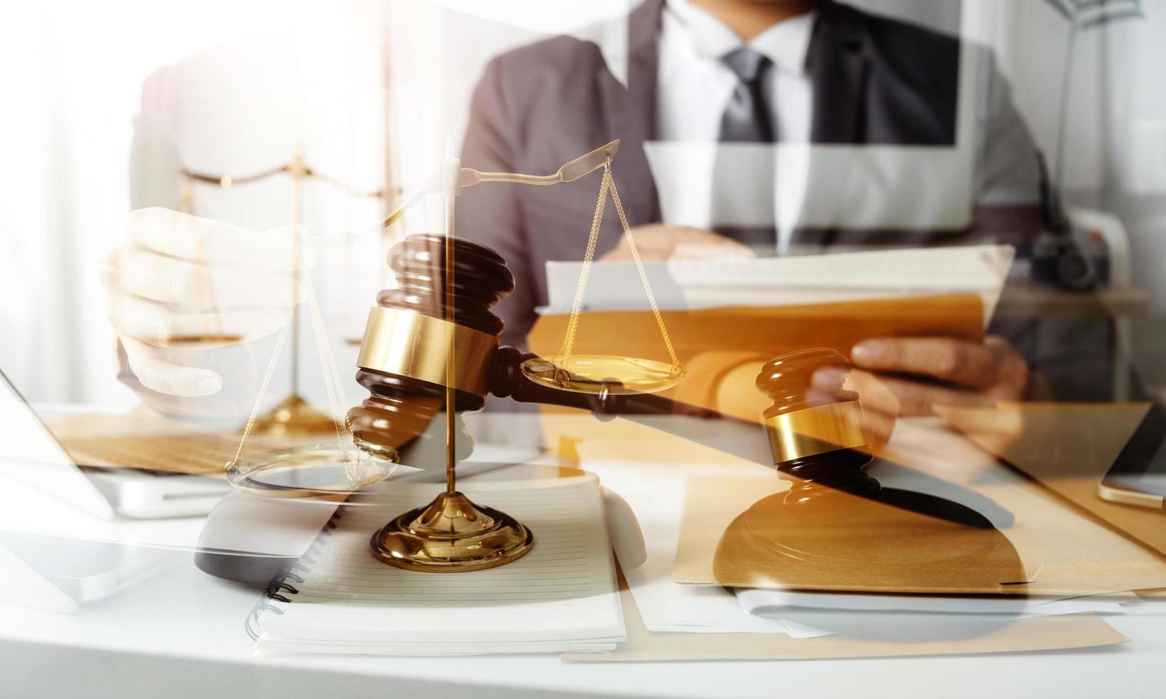 Justice and law concept.Male judge in a courtroom with the gavel, working with, computer and docking keyboard, eyeglasses, on table in morning light photo