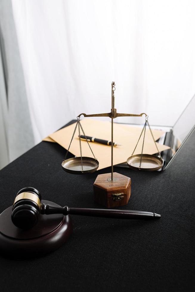 Justice and law concept.Male judge in a courtroom with the gavel, working with, computer and docking keyboard, eyeglasses, on table in morning light photo