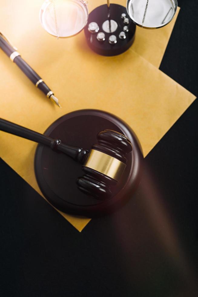 Business and lawyers discussing contract papers with brass scale on desk in office. Law, legal services, advice, justice and law concept picture with film grain effect photo