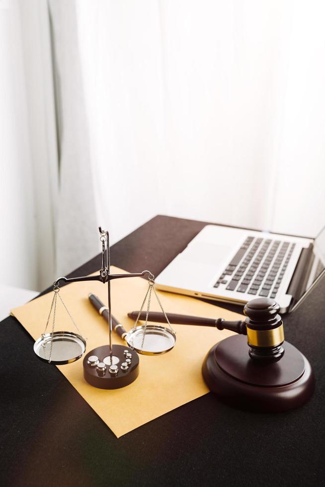 Justice and law concept.Male judge in a courtroom with the gavel, working with, computer and docking keyboard, eyeglasses, on table in morning light photo