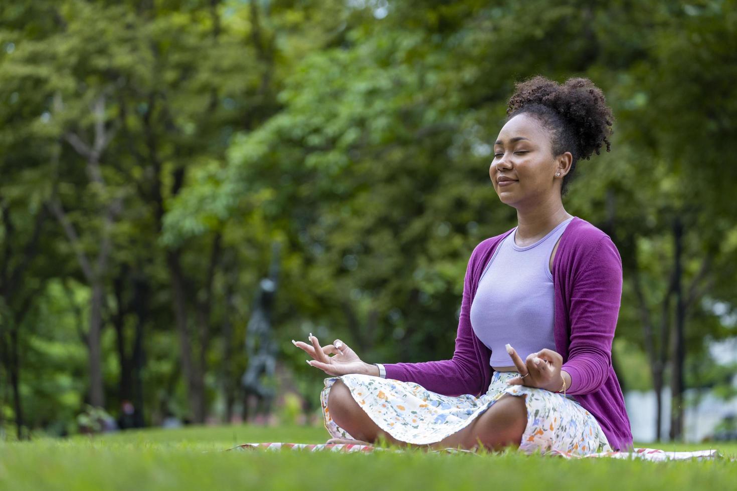 African American woman relaxingly practicing meditation in the forest to attain happiness from inner peace wisdom for healthy mind and soul photo