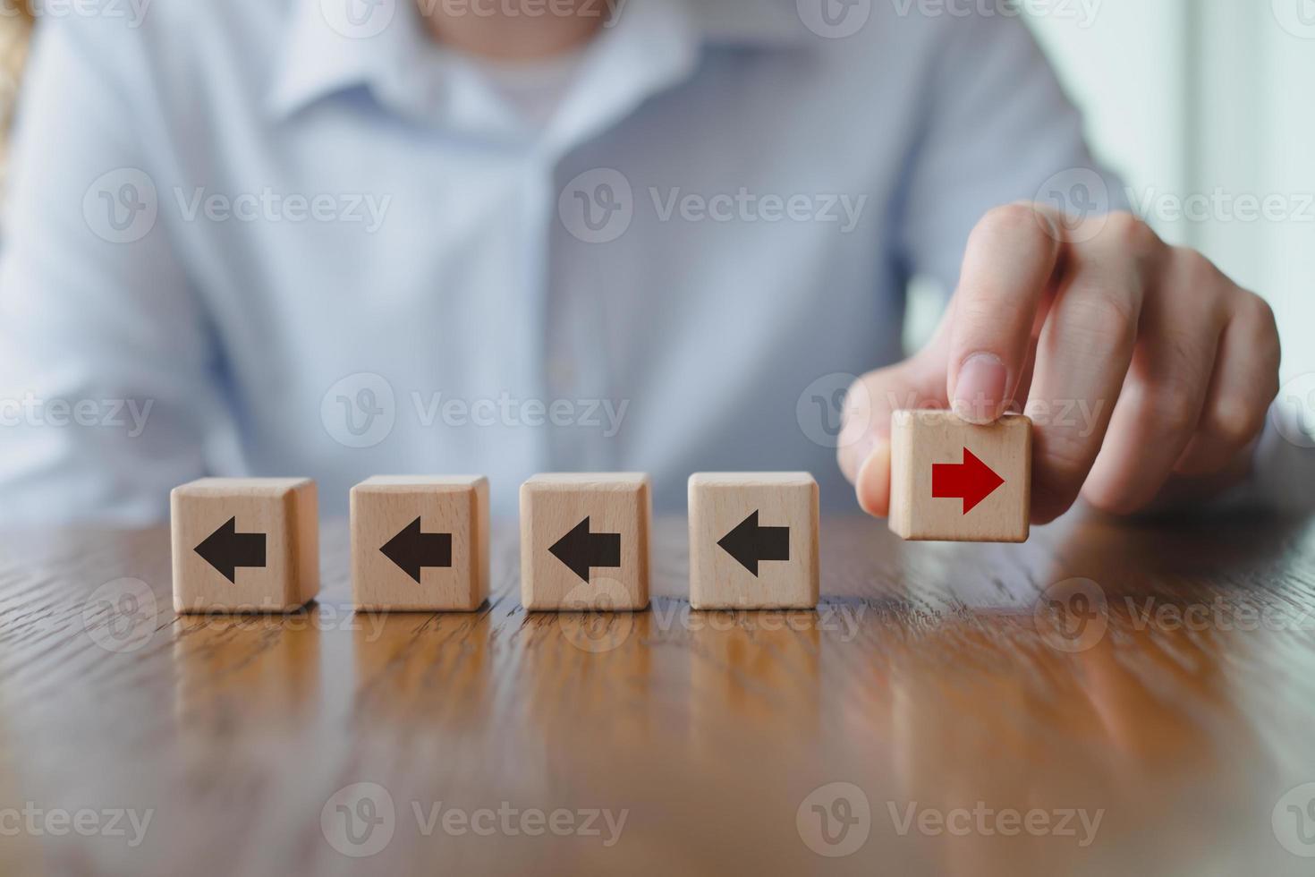 mano que sostiene la flecha roja que la dirección opuesta a la flecha negra. individualidad, pensar fuera de la caja, pensar la diferencia. interrupción del negocio y liderazgo. foto