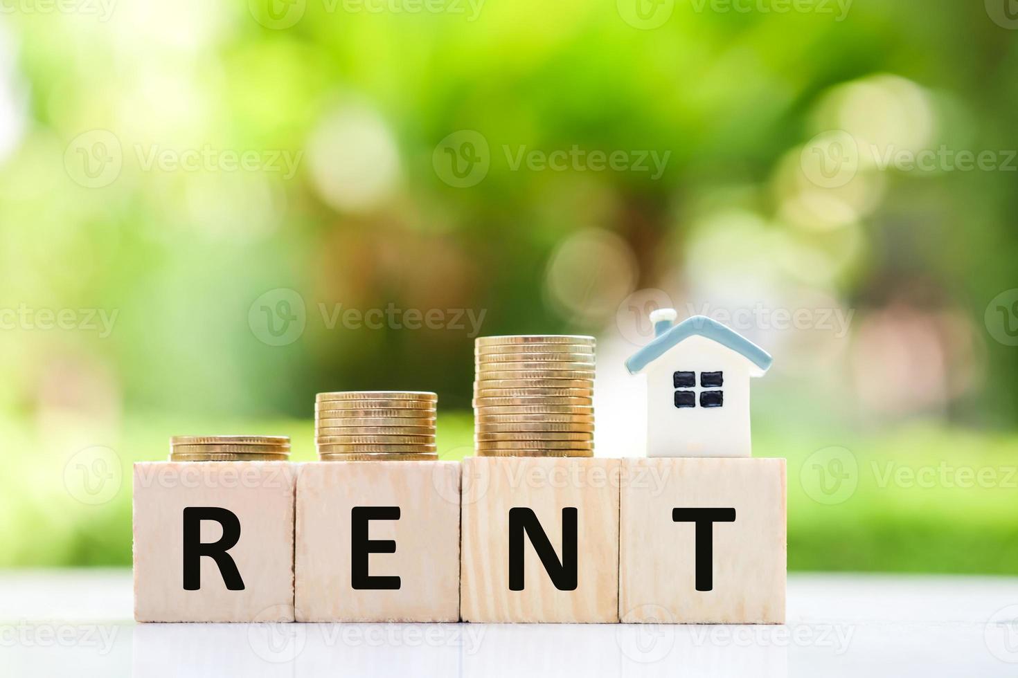 Real estate concept. House for rent. house model and stack of coin. Payment for temporary use of a property owned by another owner, tenant unwilling to pay full price, avoid burden of upkeep. photo