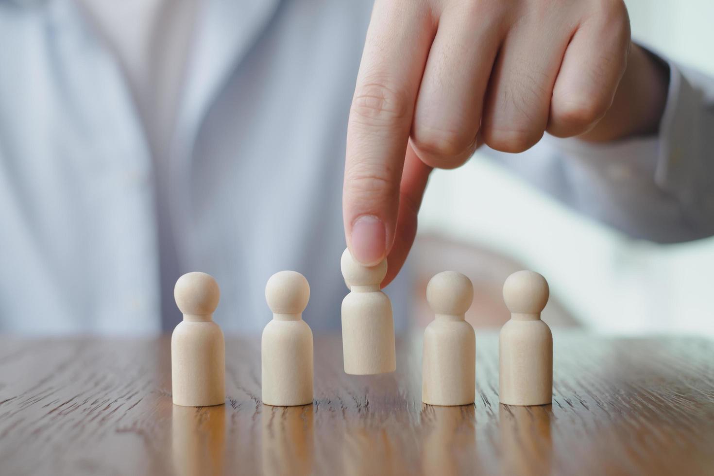 Hand Choose figure standing out from the group of crowd. Business hiring and recruitment selection. Choice of employee leader from the crowd. Career opportunity. Human Resource Management. photo