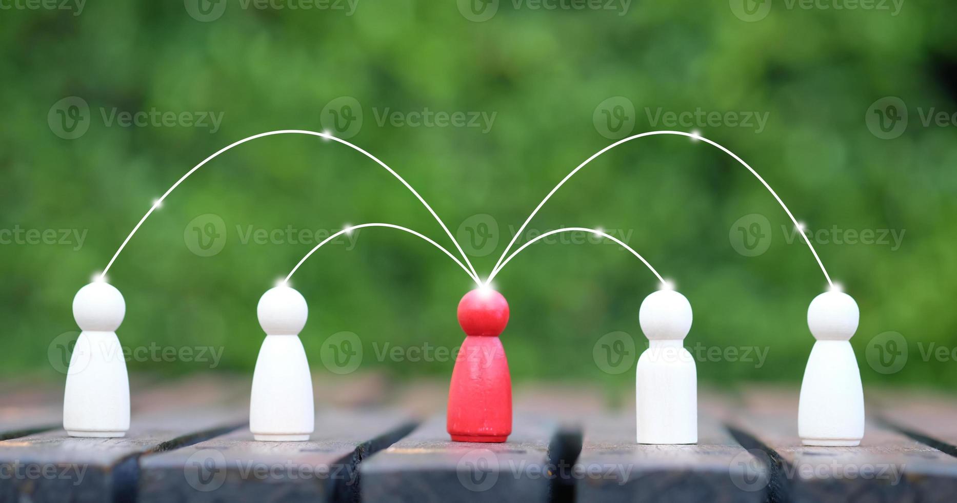 Wooden person figure standing in front of the team with line connection symbol for spreads influence to people through a communication network. Social connections. Leader and leadership, coordination. photo