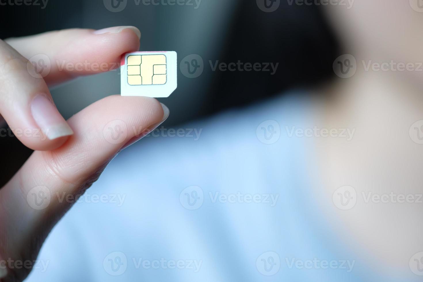 mano de mujer con tarjeta sim blanca. concepto de tecnología. foto