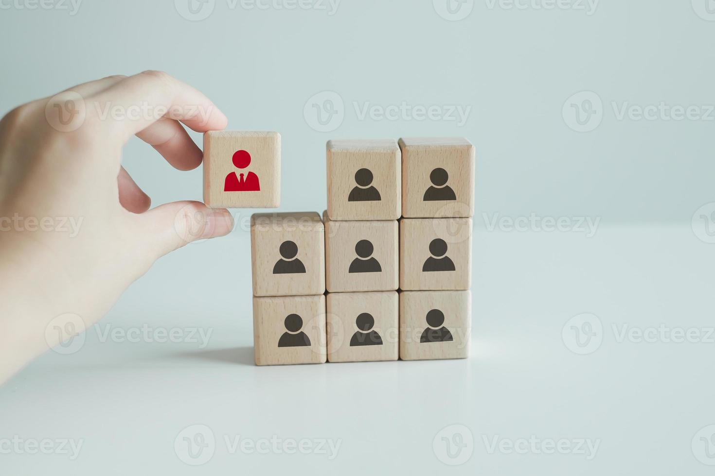 Human resources management and recruitment business hiring concept, corporate hierarchy, recruiter complete team by one leader person, professional staff research, hand hold red people icon on cube. photo