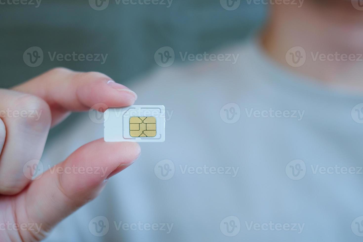 Man hand holding white sim card. Technology concept. photo