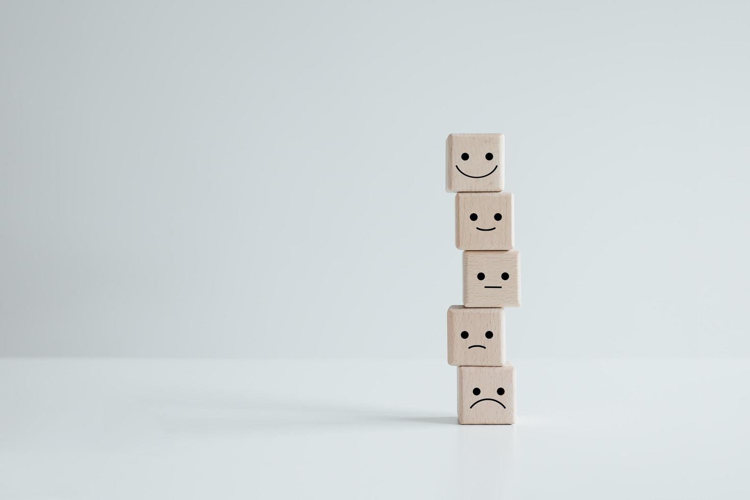 Customer service rating experience and feedback emotion and satisfaction survey concept. wood cube with smile, normal and sad face. Negative, neutral and positive facial expressions. photo