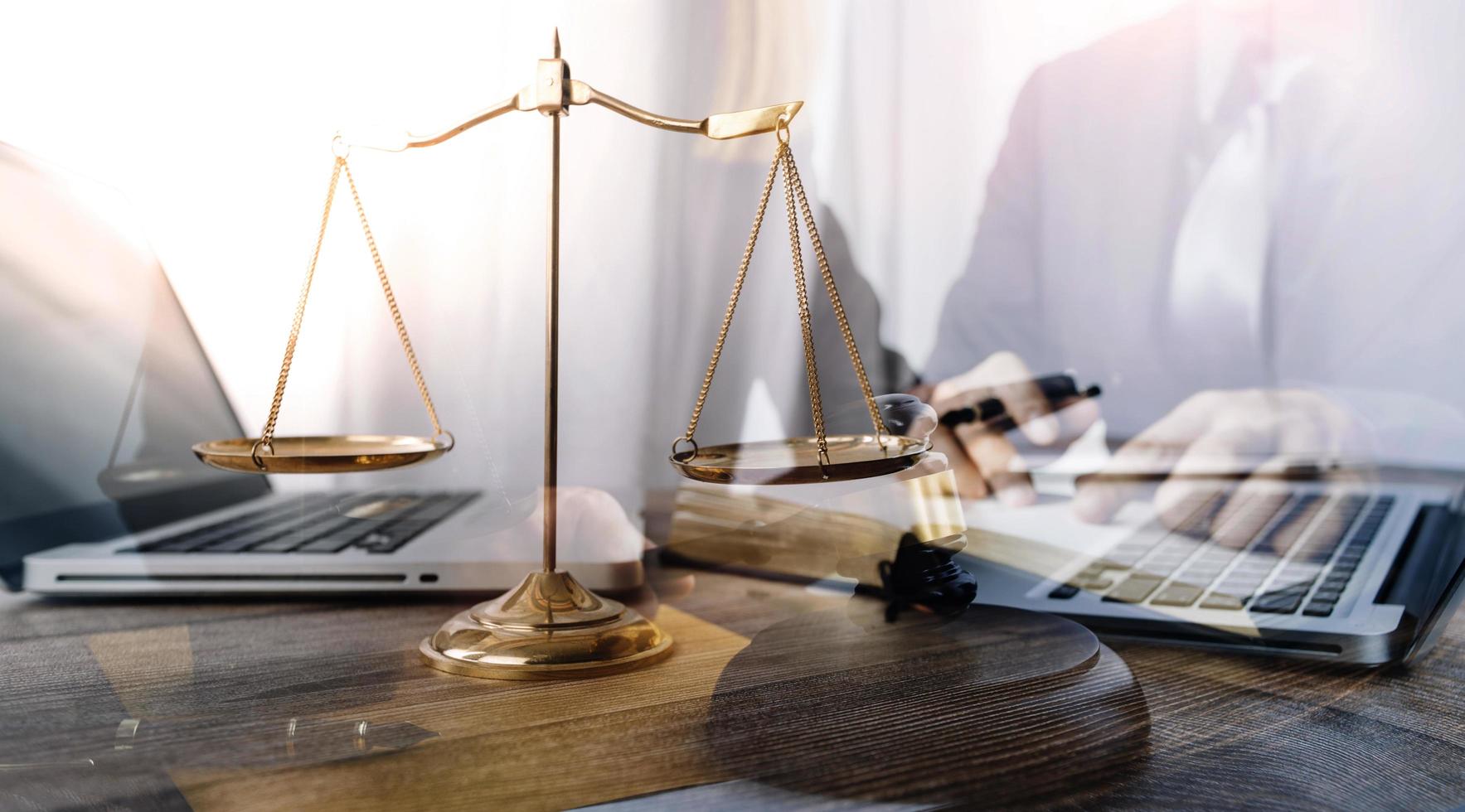 Business and lawyers discussing contract papers with brass scale on desk in office. Law, legal services, advice, justice and law concept picture with film grain effect photo