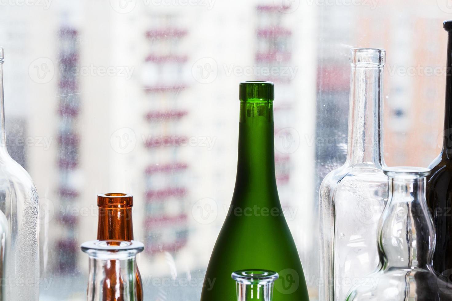 several empty bottles and view of urban houses photo