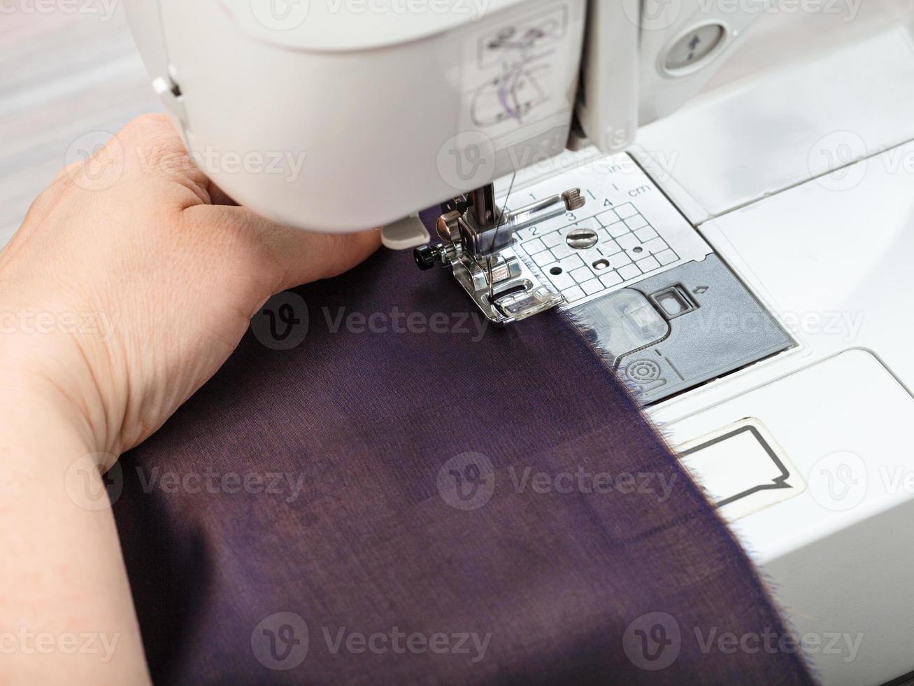 needlewoman sews strips of fabrics for patchwork photo