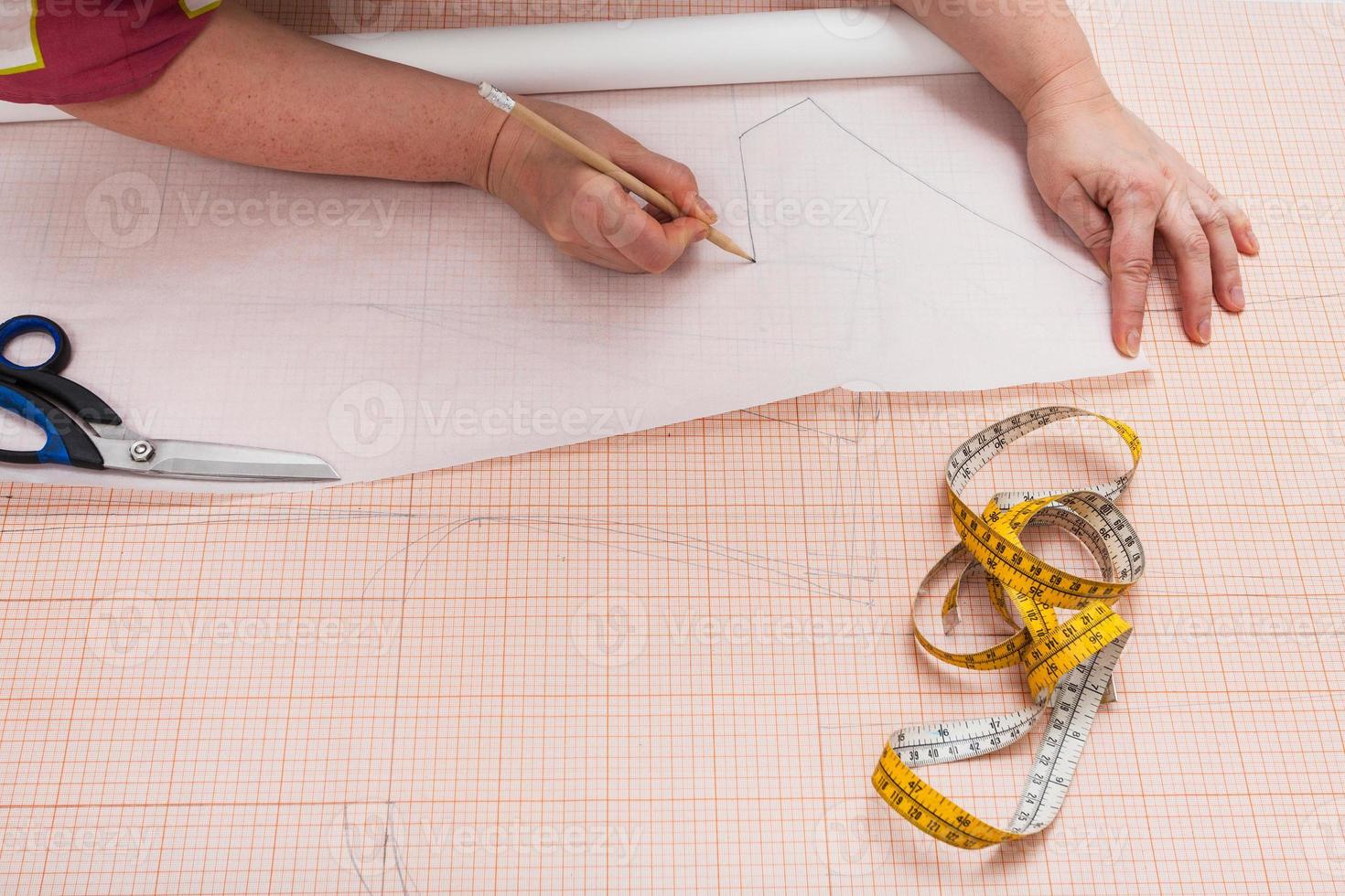 tailor tracing a clothing pattern on tracing-paper photo