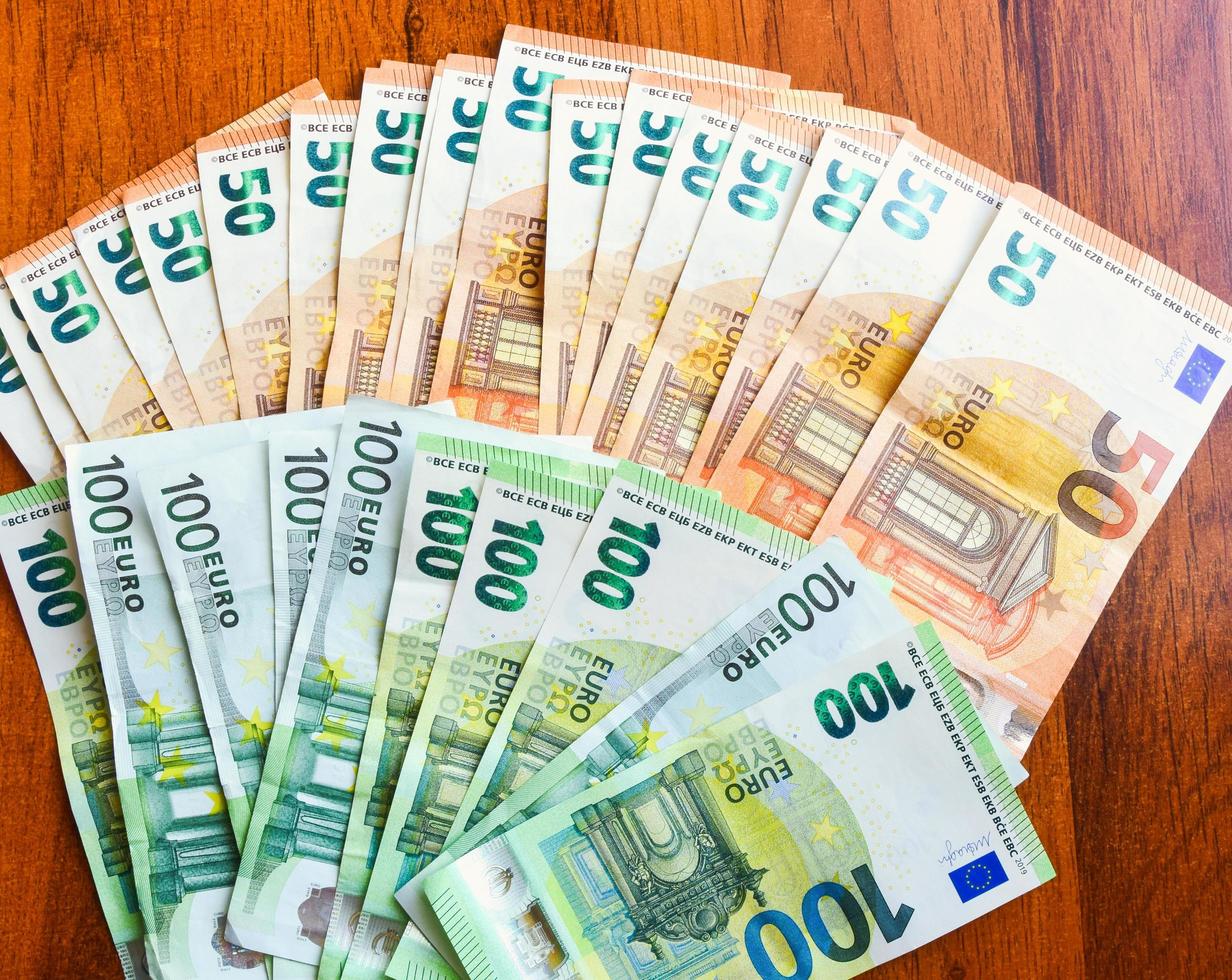 Two Thousand Euros Spreaded On Wooden Table Background Top View two-thousand-euros-spreaded-on-wooden-table-background-top-view