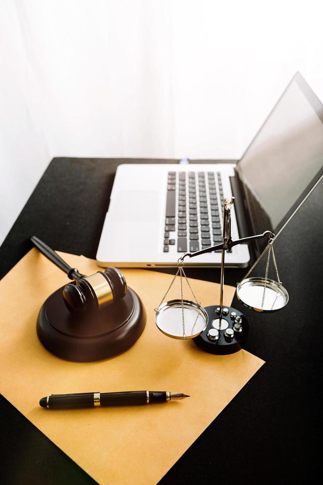 Justice and law concept.Male judge in a courtroom with the gavel, working with, computer and docking keyboard, eyeglasses, on table in morning light photo