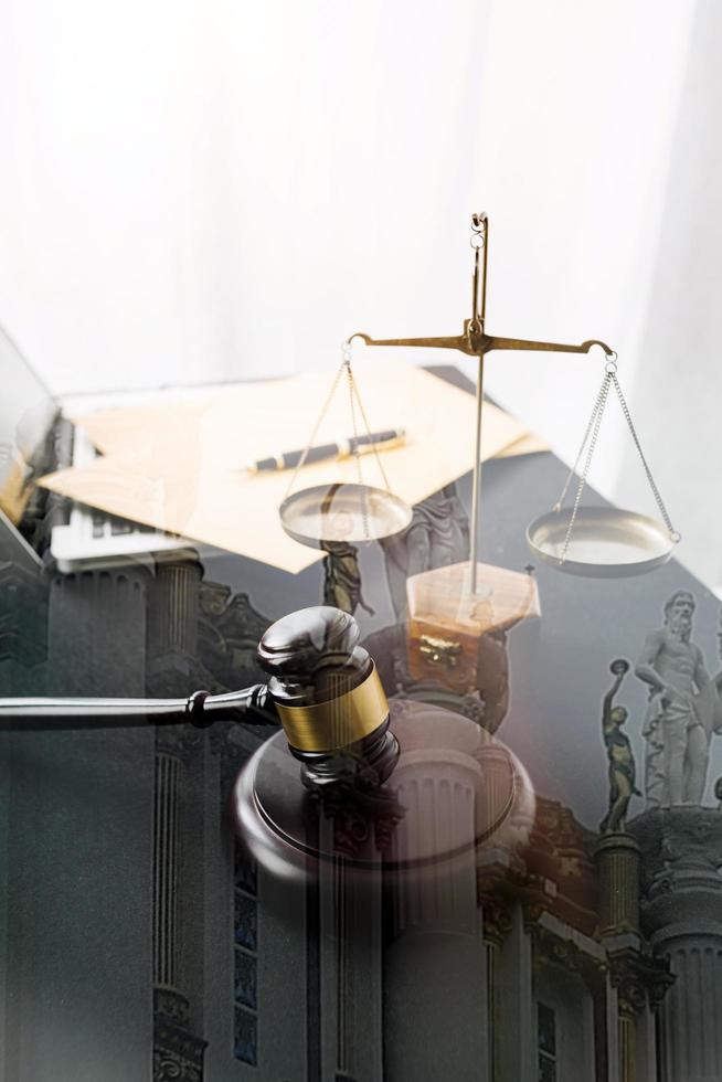 Justice and law concept.Male judge in a courtroom with the gavel, working with, computer and docking keyboard, eyeglasses, on table in morning light photo