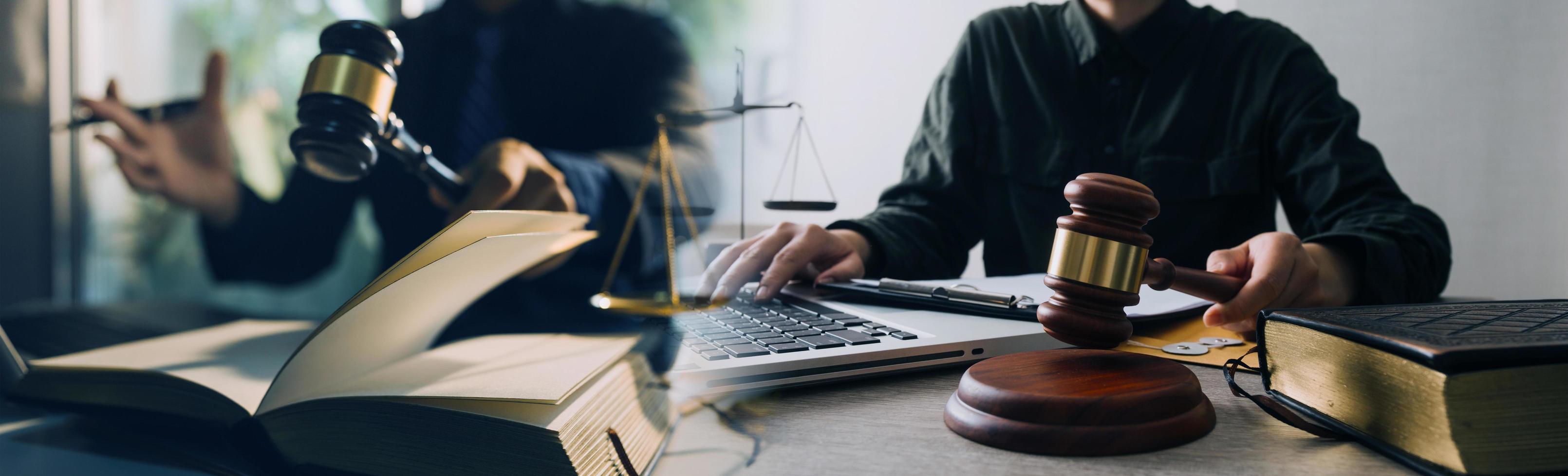 concepto de justicia y derecho. mazo en el bloque de sonido en la mano del juez masculino en una sala del tribunal, trabajando con libros de derecho de documentos, informe el caso sobre la mesa en la oficina moderna. foto