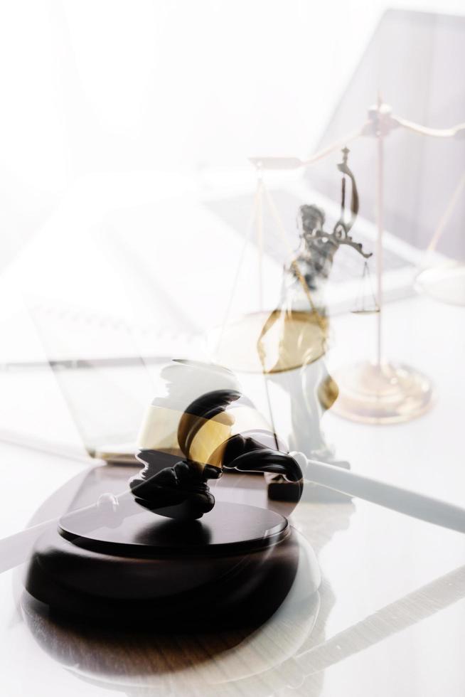 Justice and law concept.Male judge in a courtroom with the gavel, working with, computer and docking keyboard, eyeglasses, on table in morning light photo