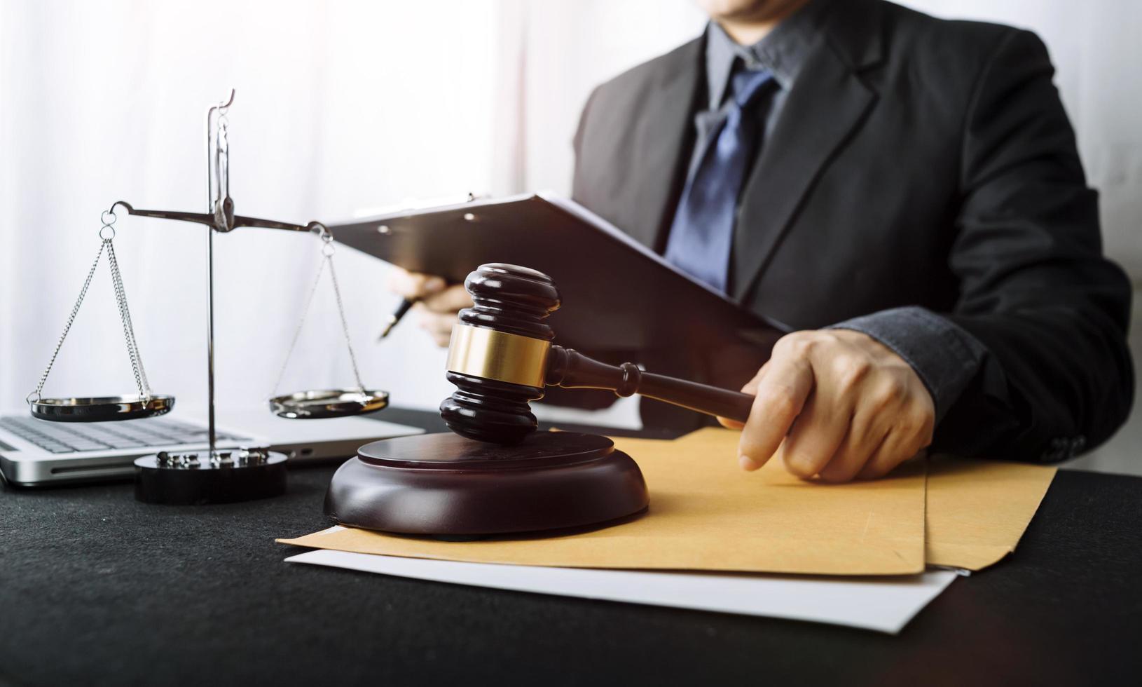 Business and lawyers discussing contract papers with brass scale on desk in office. Law, legal services, advice, justice and law concept picture with film grain effect photo