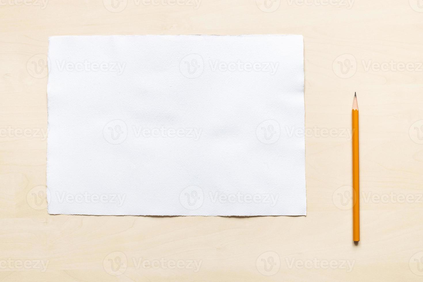 wooden pencil near blank sheet of white paper photo
