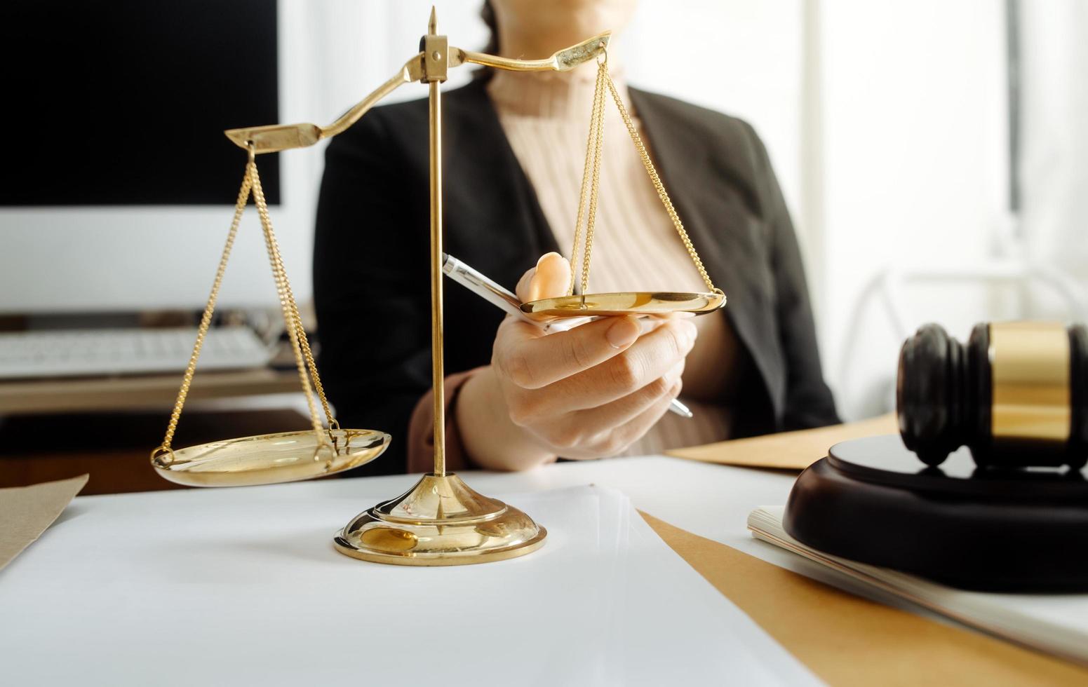 Justice and law concept.Male judge in a courtroom with the gavel, working with, computer and docking keyboard, eyeglasses, on table in morning light photo