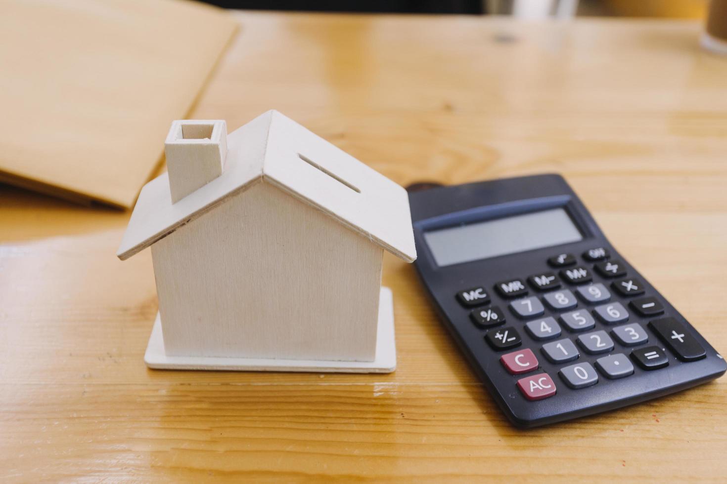 Modeling wooden houses and coins and dollars placed on wooden tables,preparation concept for house model purchase and the fastest growing real estate economy,moving home or renting property via agent photo