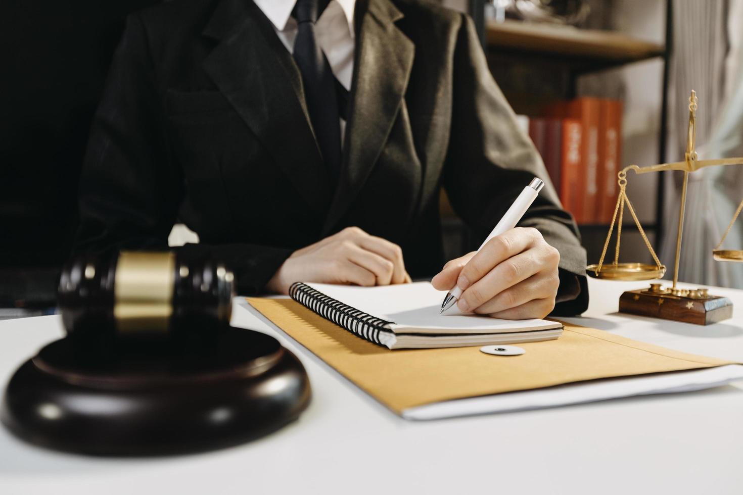 Business and lawyers discussing contract papers with brass scale on desk in office. Law, legal services, advice, justice and law concept picture with film grain effect photo