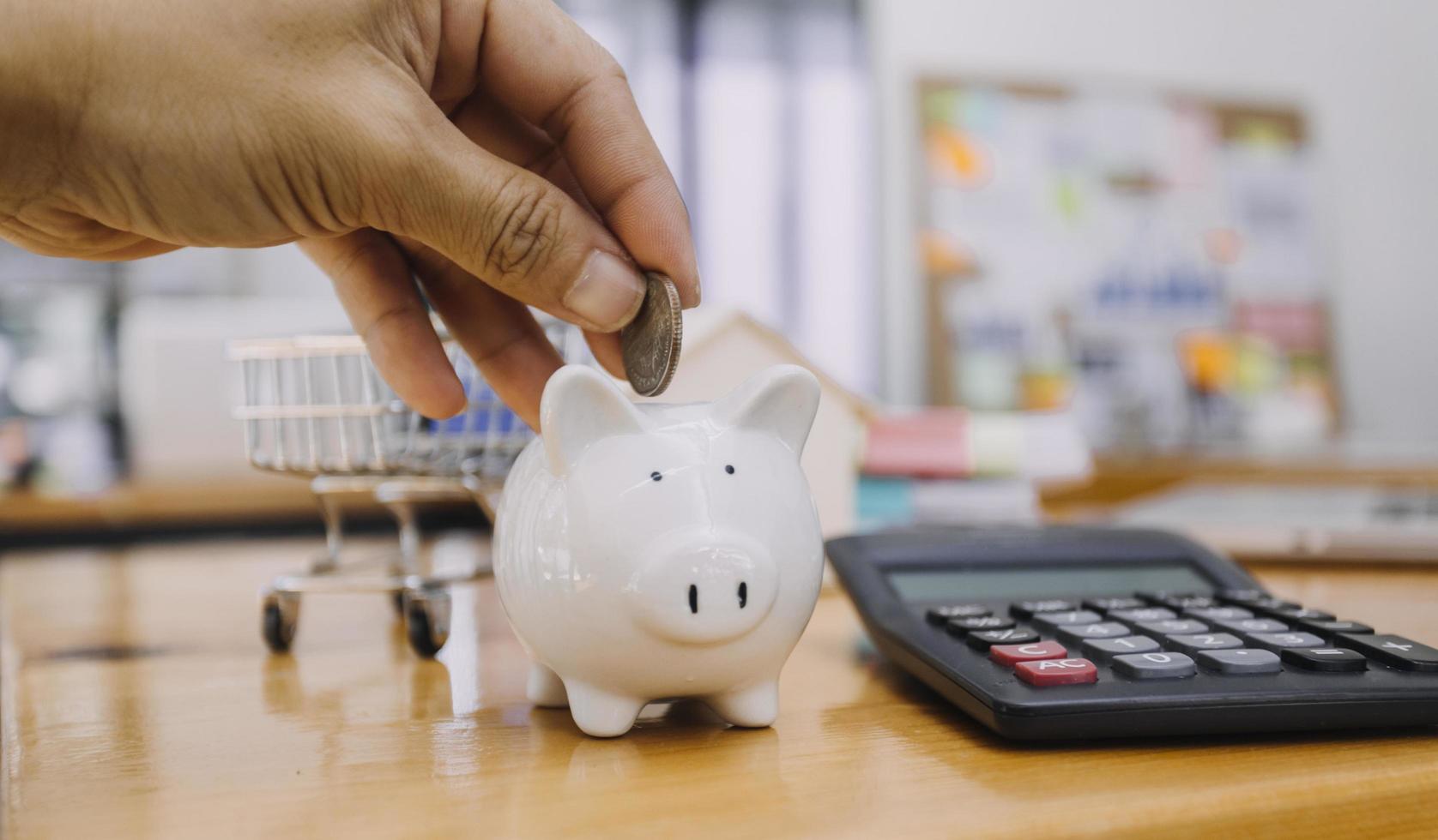 businessman hand putting coin in piggy bank. Saving money concept, business finance and investment. photo