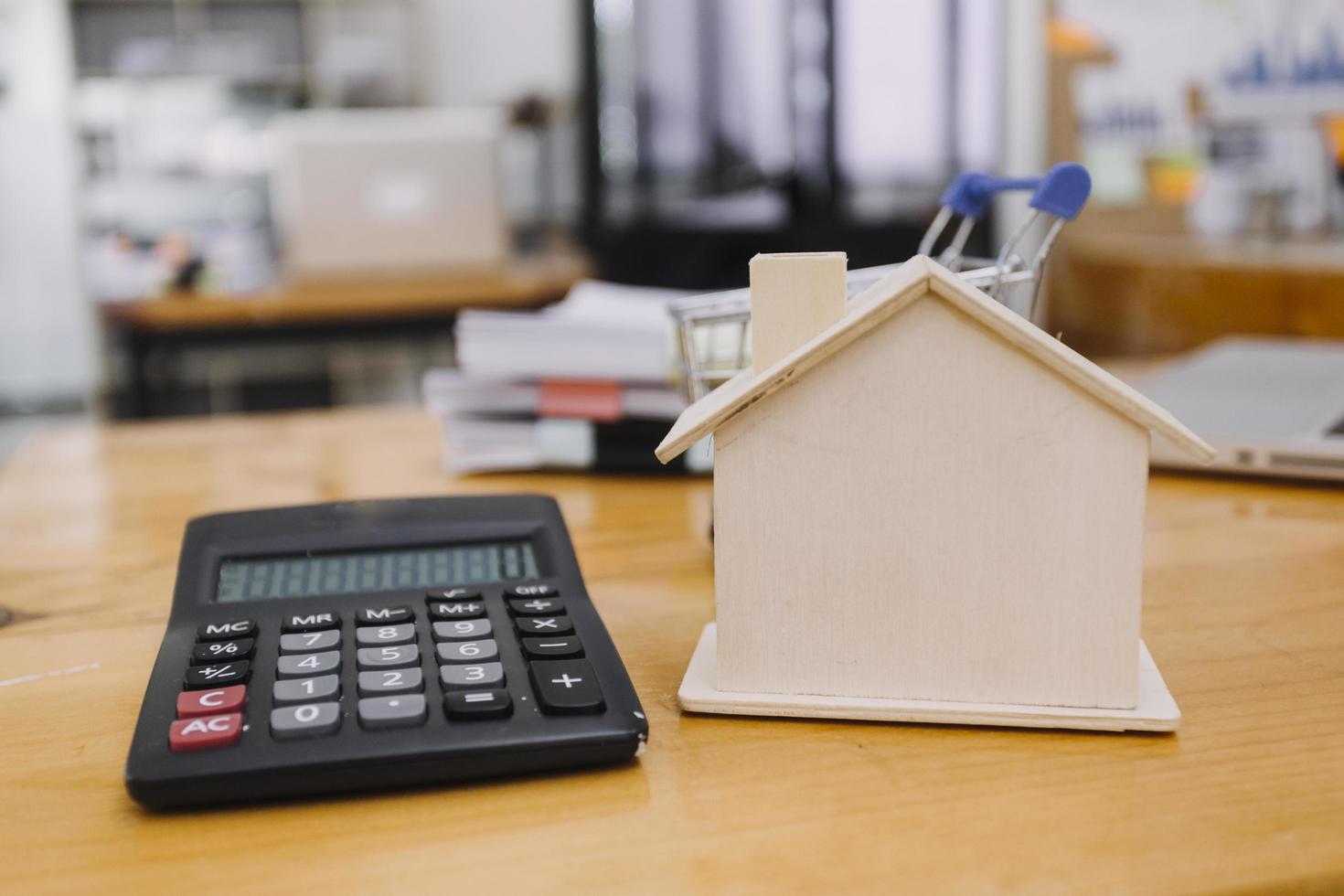 Modeling wooden houses and coins and dollars placed on wooden tables,preparation concept for house model purchase and the fastest growing real estate economy,moving home or renting property via agent photo