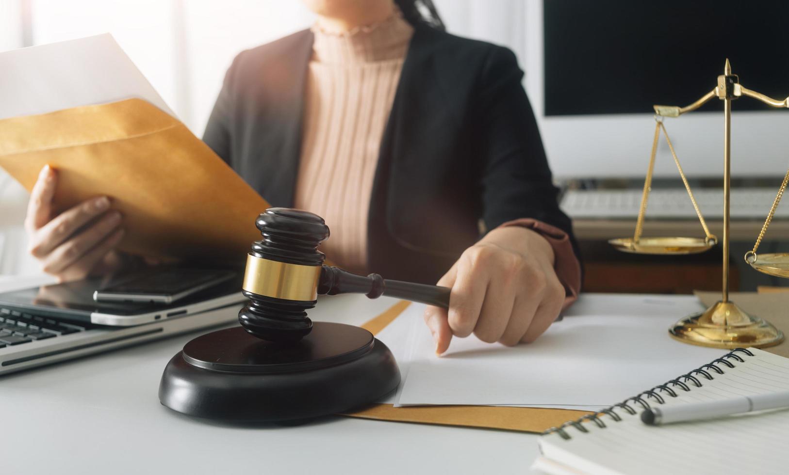 Business and lawyers discussing contract papers with brass scale on desk in office. Law, legal services, advice, justice and law concept picture with film grain effect photo