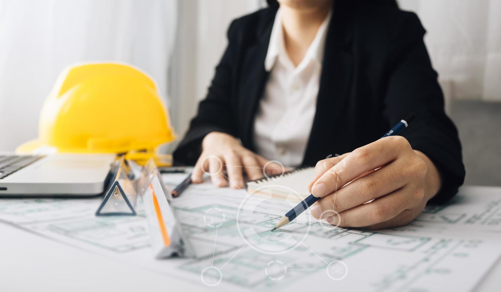 Two colleagues discussing data working and tablet, laptop with on on architectural project at construction site at desk in office photo