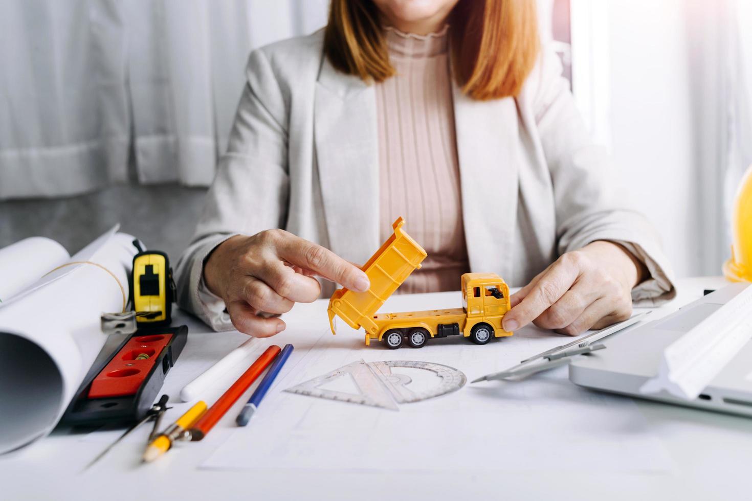 business hand working and laptop with on on architectural project at construction site at office desk in office photo