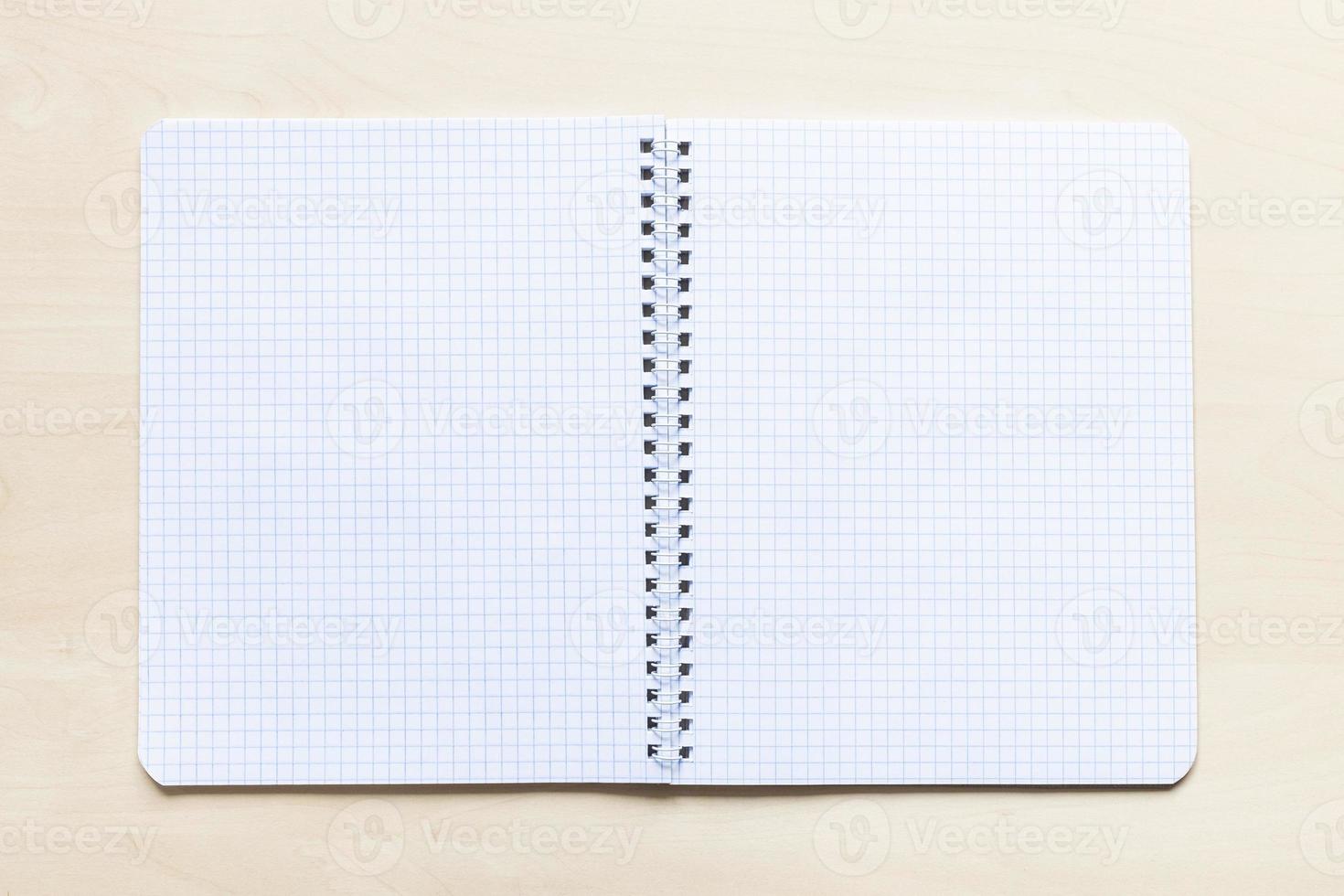 open blank spiral notebook on light brown board photo