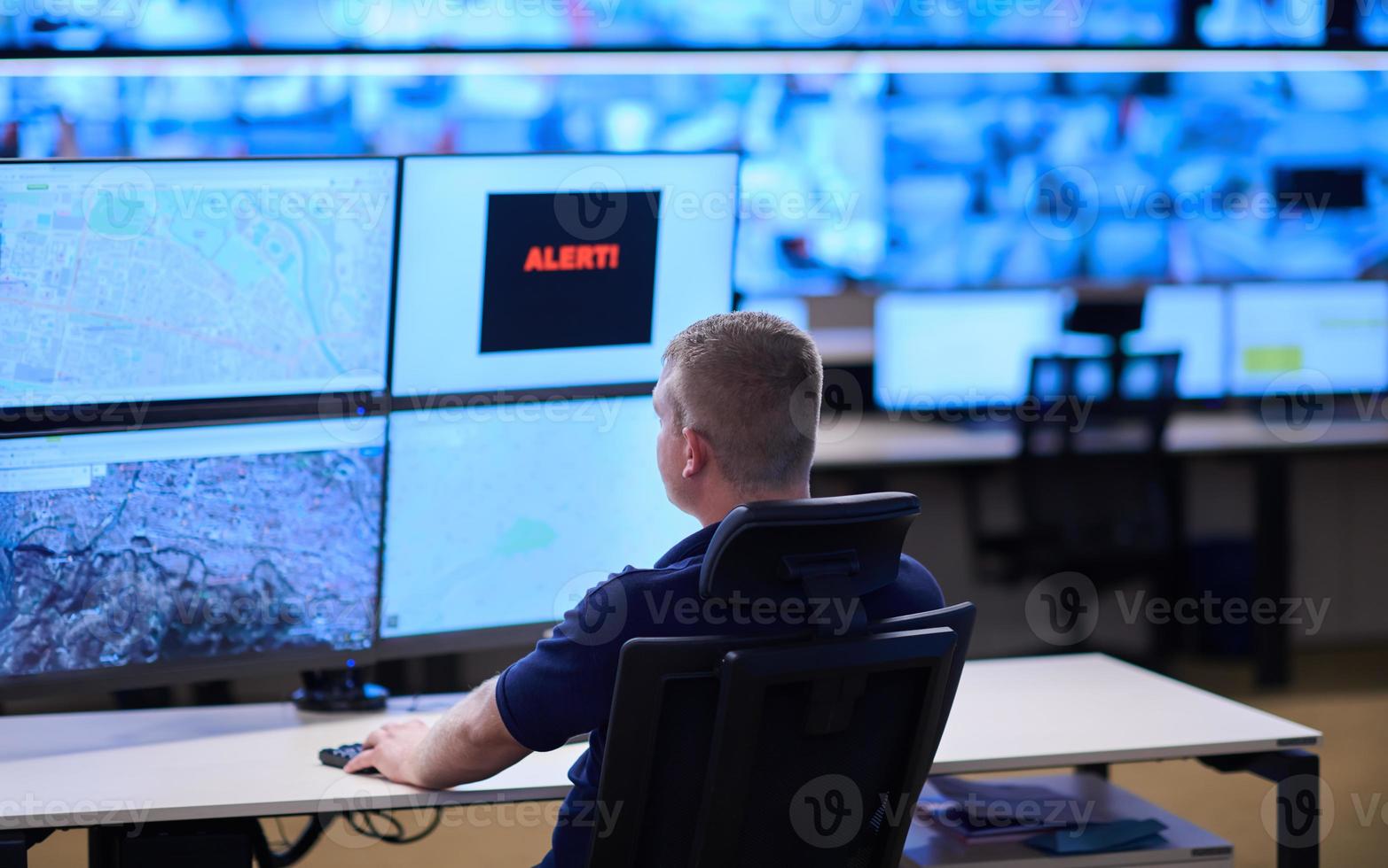 young male operator working in a security data system control room photo