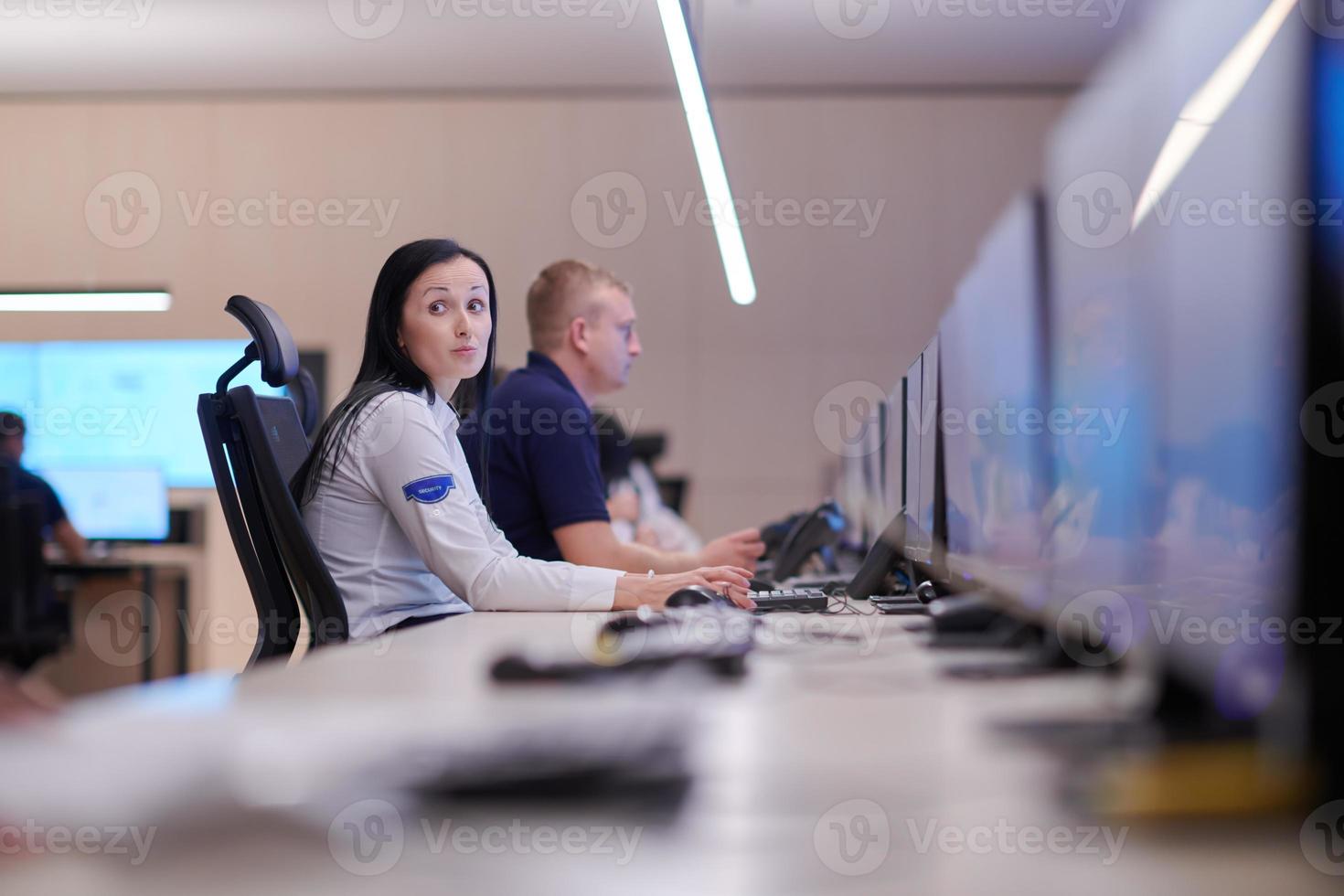 Female operator working in a security data system control room photo