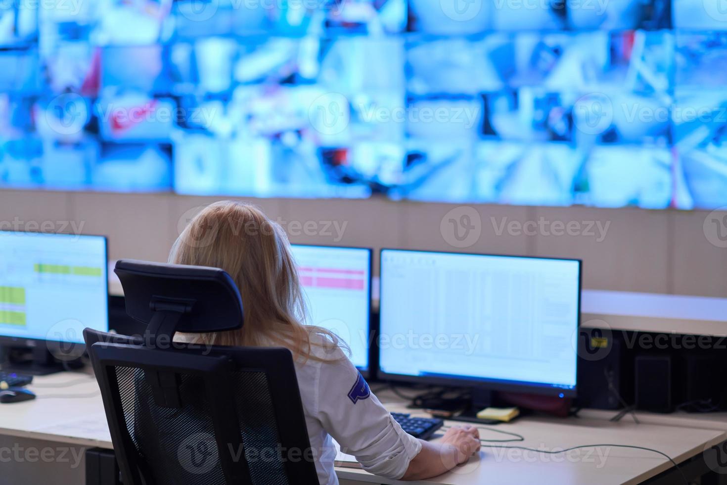 Female operator working in a security data system control room photo