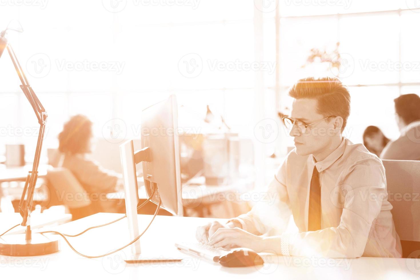 Young businessman using computer at work photo
