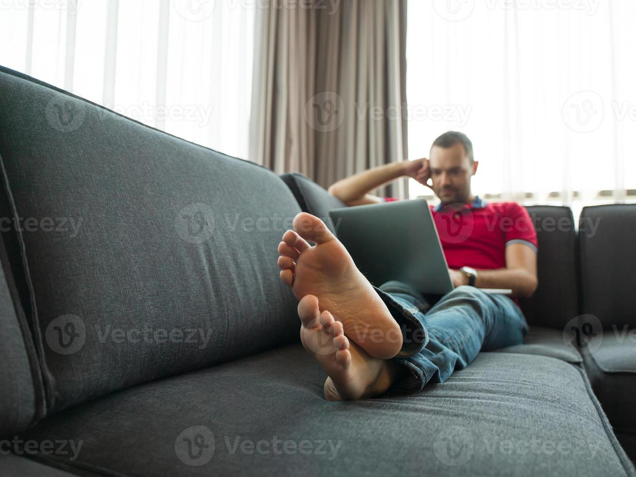 Man using laptop in living room photo