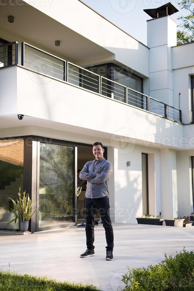 man in front of his luxury home villa photo