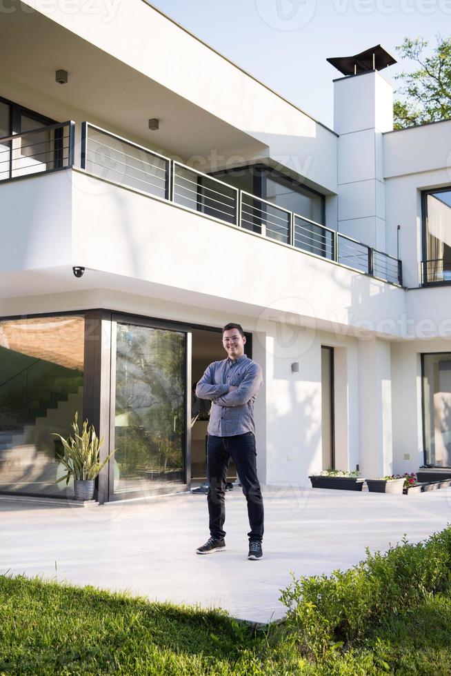 man in front of his luxury home villa photo