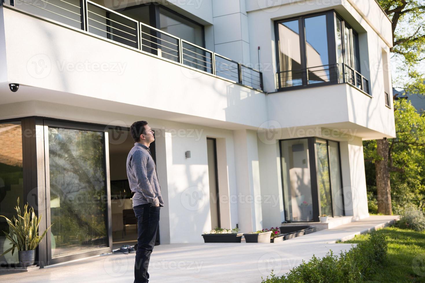 man in front of his luxury home villa photo