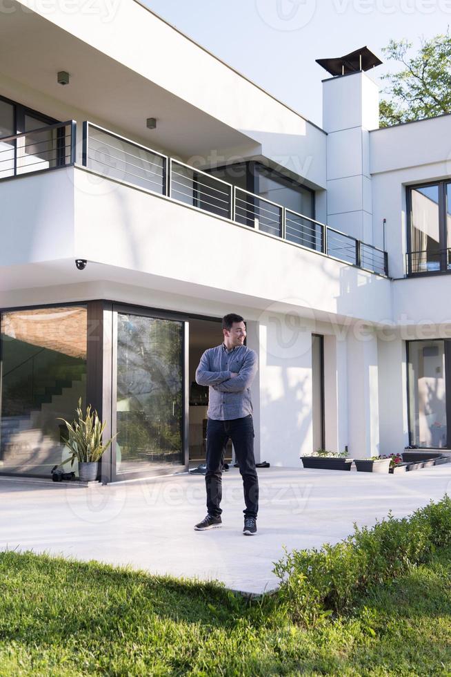 man in front of his luxury home villa photo