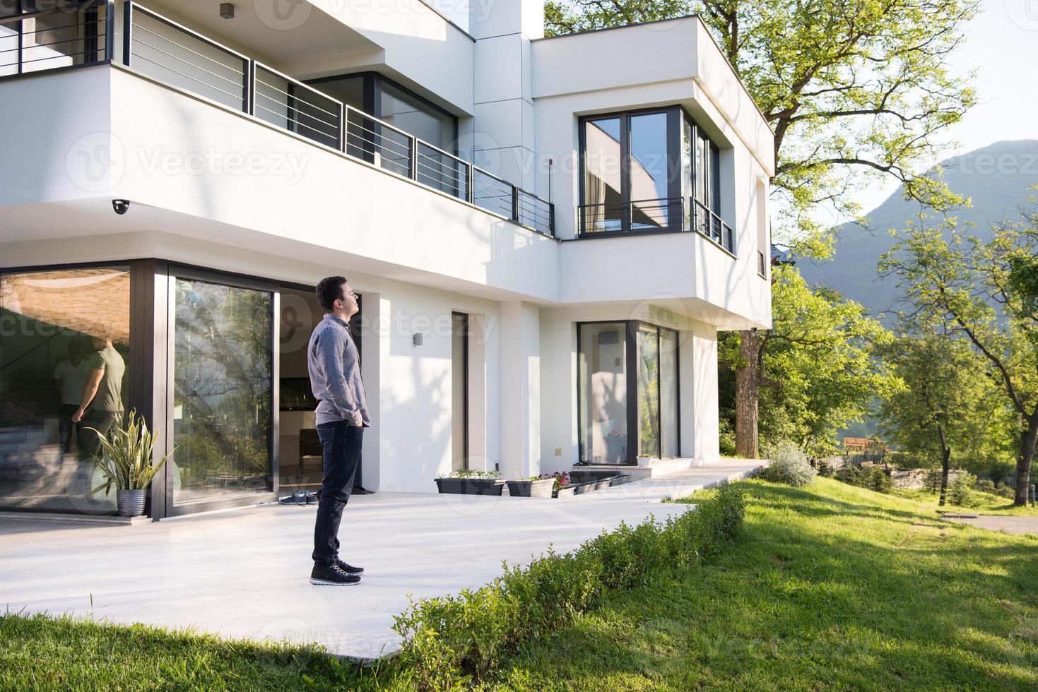 man in front of his luxury home villa photo