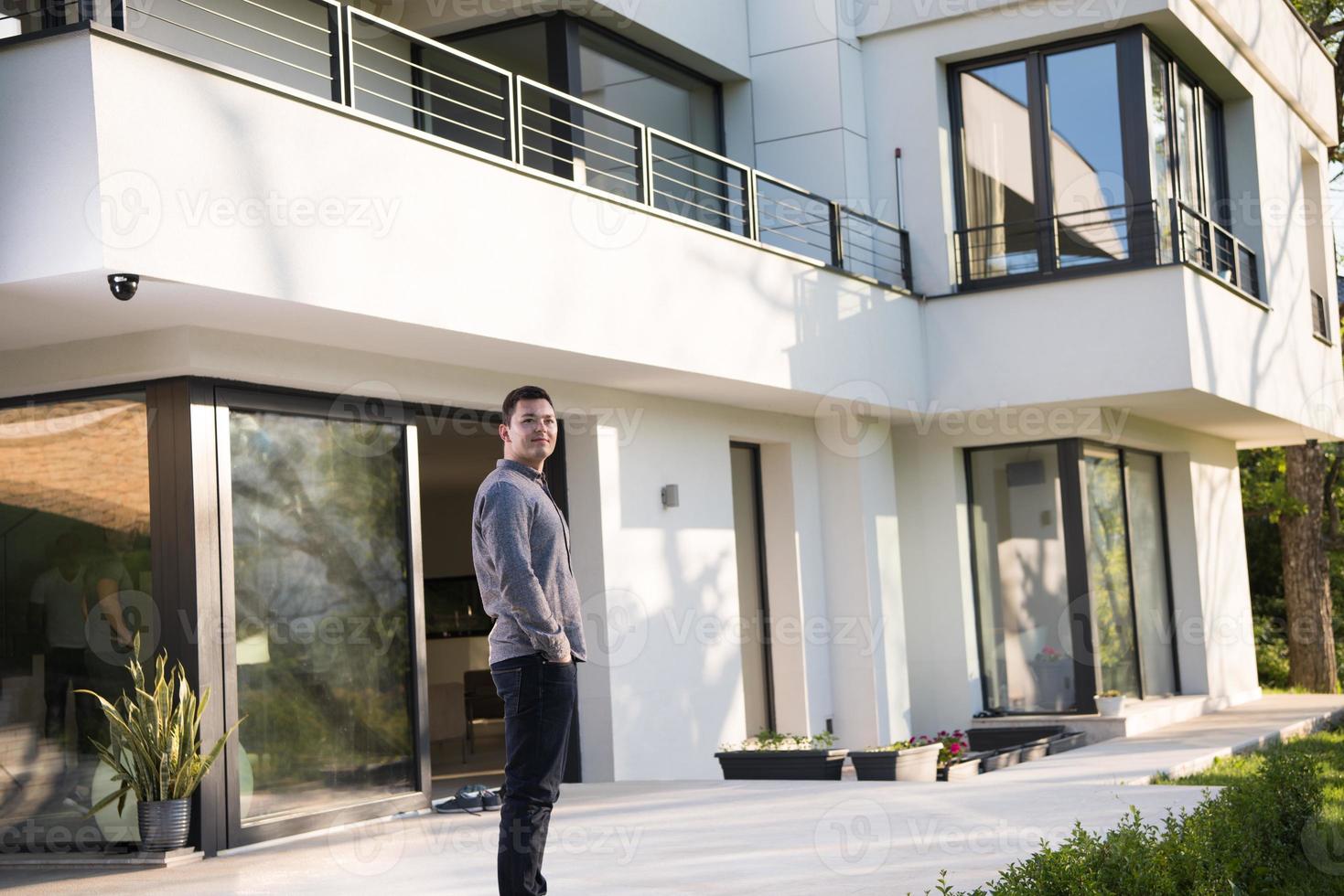 man in front of his luxury home villa photo