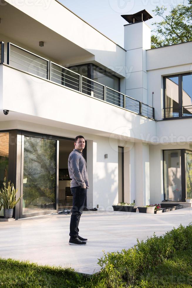 man in front of his luxury home villa photo