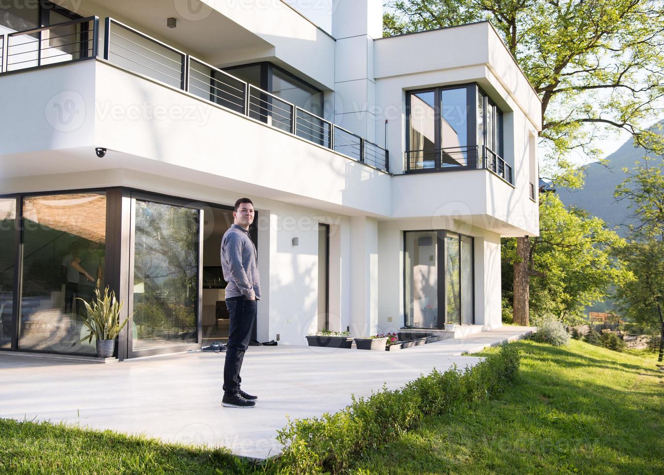man in front of his luxury home villa photo