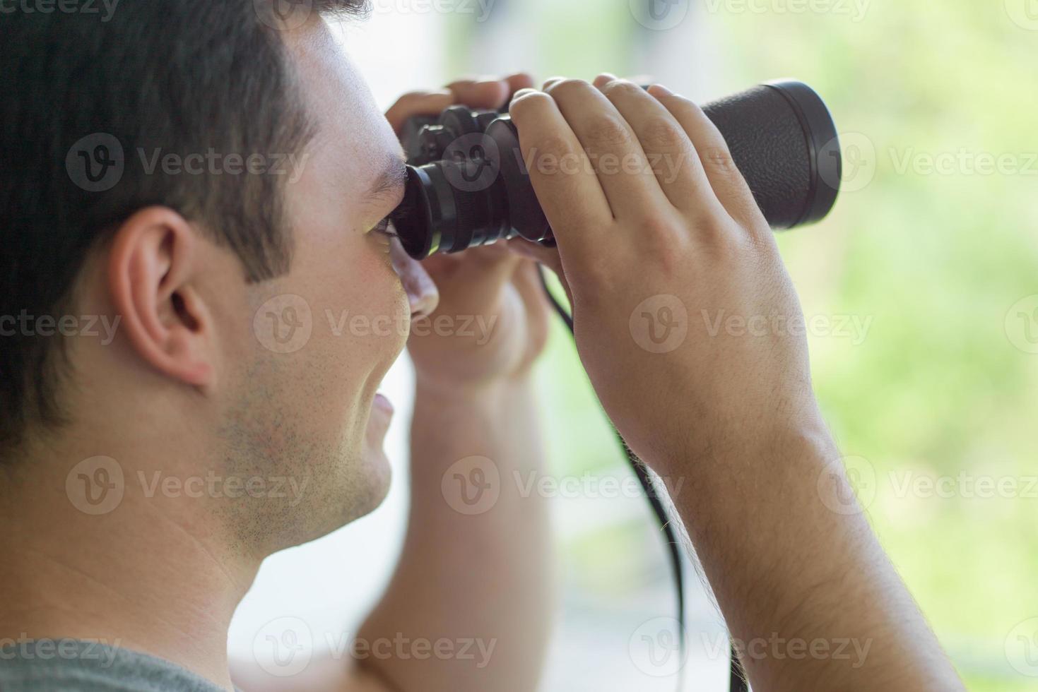 hombre mirando con binoculares foto