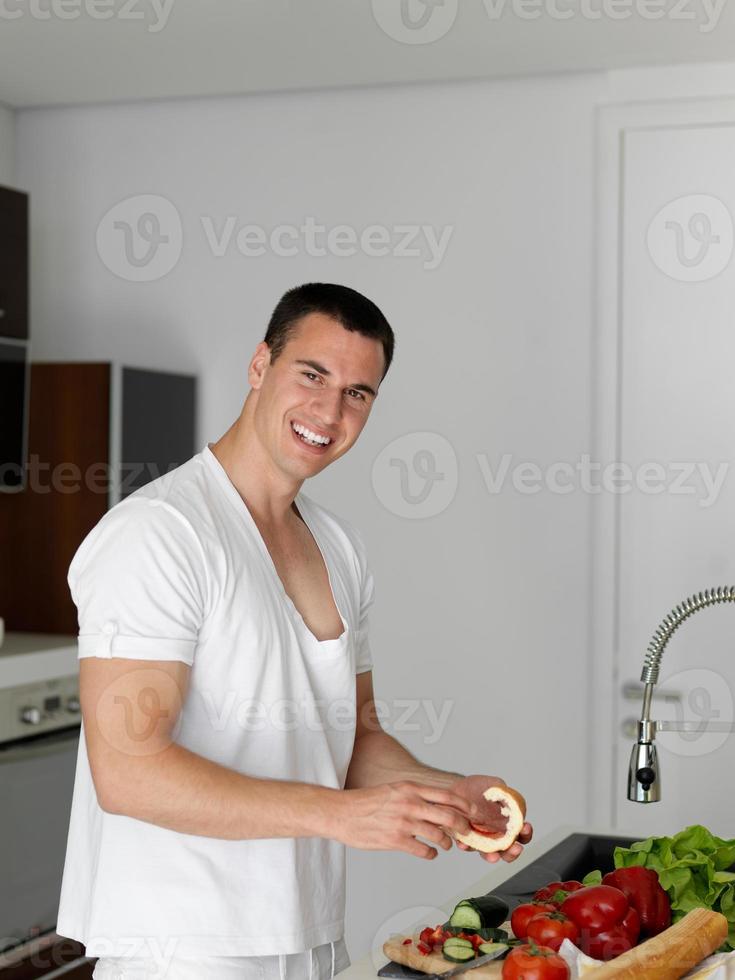 man cooking at home preparing salad in kitchen photo