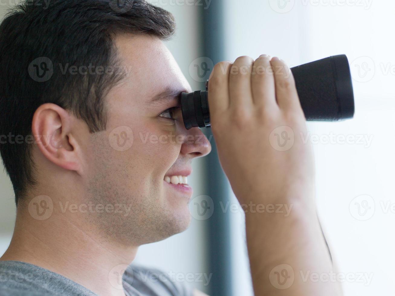 man looking with binoculars photo